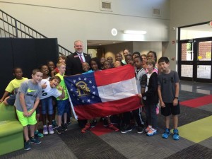 Rep. Gravley presenting the State Flag of Georgia to the Brighten Academy students. 